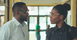 A parent and a teacher having a conversation in a hallway